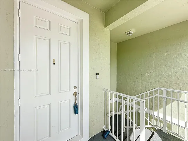 a view of a hallway with wooden floor and entryway