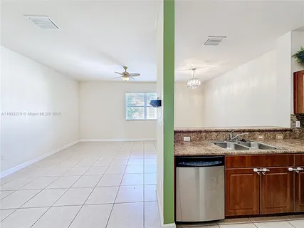 a view of kitchen with granite countertop cabinets and sink