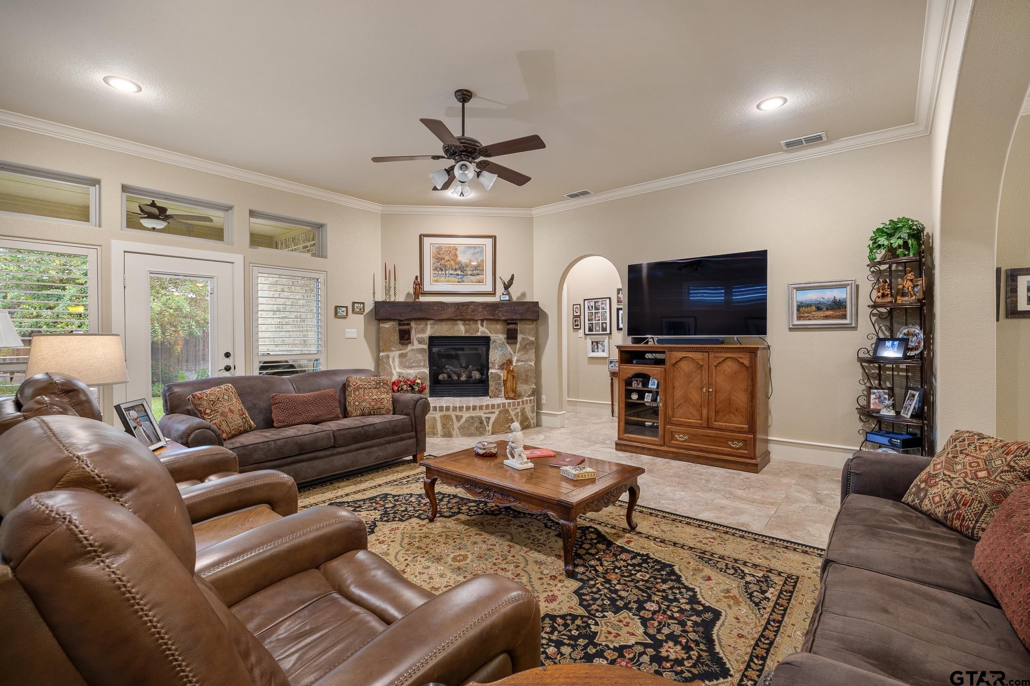 4322 Madera Drive Tyler, TX 75707 - Photo 18 of 32 a living room with furniture a flat screen tv and a fireplace