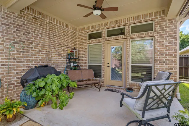 a view of a porch with chairs and potted plants
