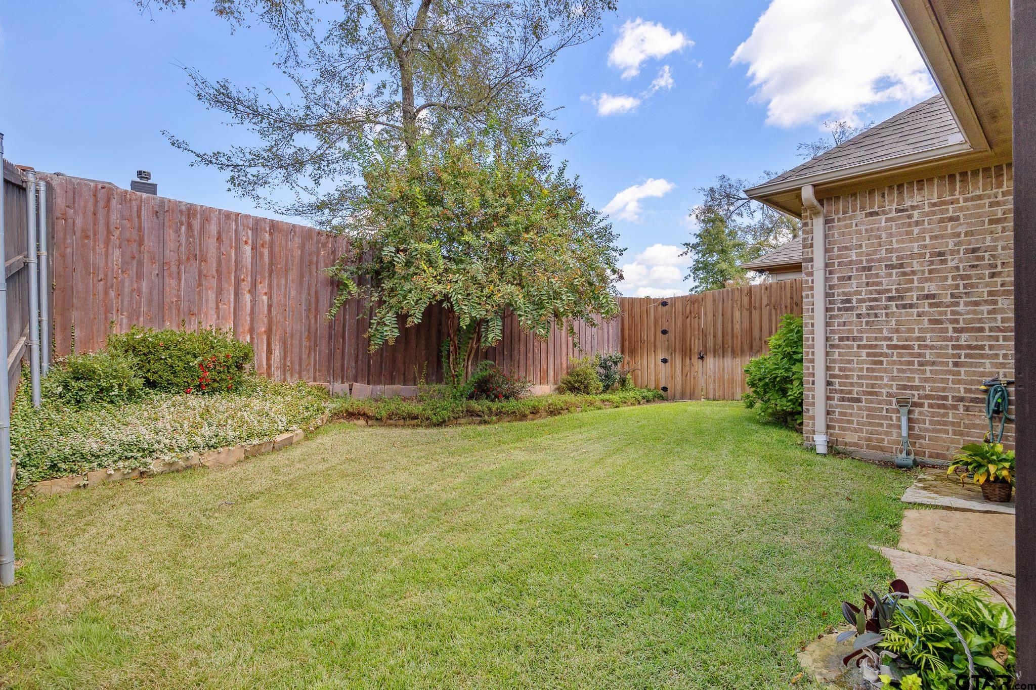 4322 Madera Drive Tyler, TX 75707 - Photo 30 of 32 a view of a backyard with potted plants and large tree