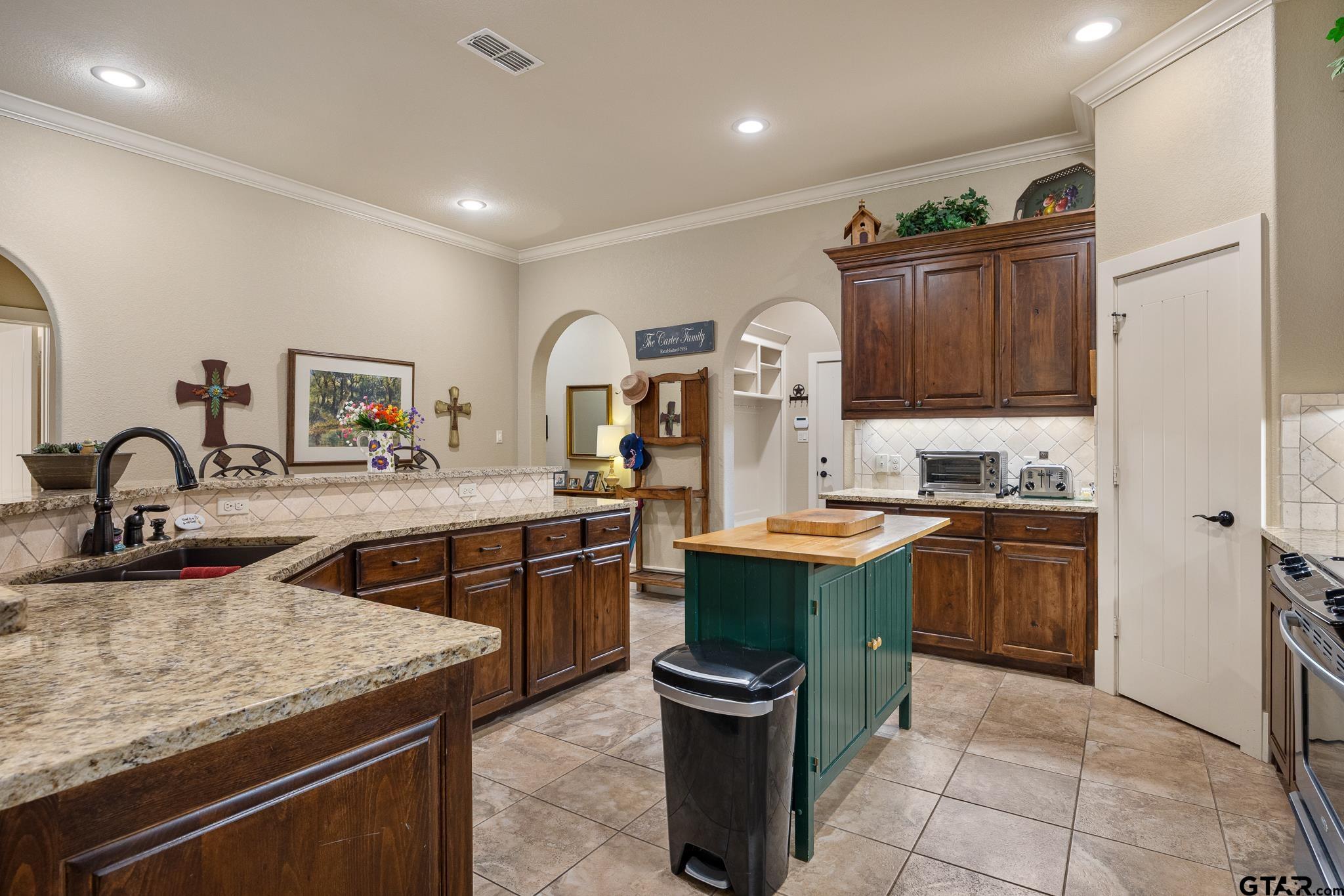4322 Madera Drive Tyler, TX 75707 - Photo 9 of 32 a kitchen with kitchen island a sink stove and cabinets