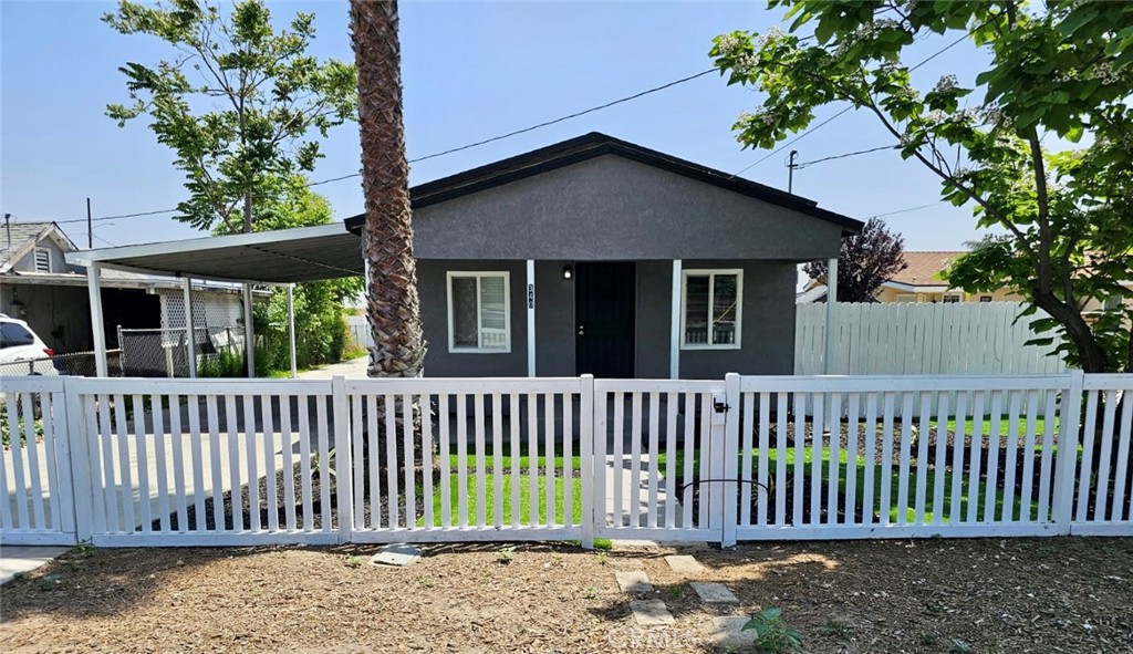 a view of a house with a small yard and a large tree front of it