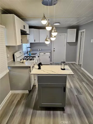 a kitchen with a sink a stove and cabinets