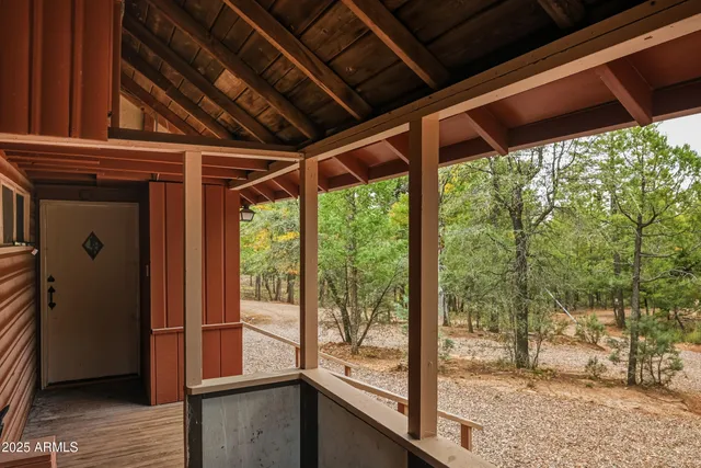 a view of an empty room with wooden floor fireplace and a window