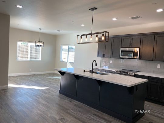1034 Ocean Avenue Ridgecrest, CA 93555 - Photo 5 of 30 a kitchen with kitchen island stainless steel appliances a sink stove and microwave