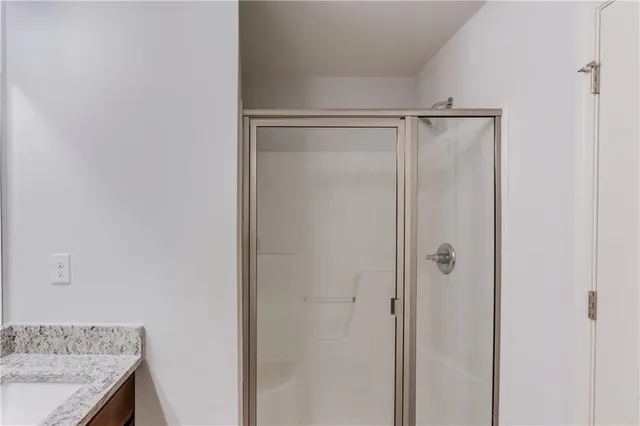 a bathroom with a granite countertop sink and shower