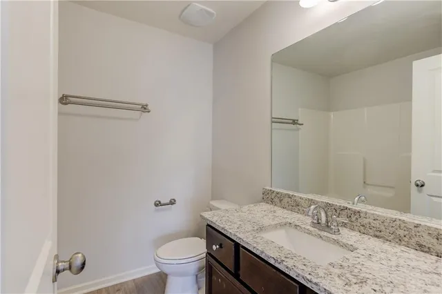 a bathroom with a granite countertop sink toilet and shower