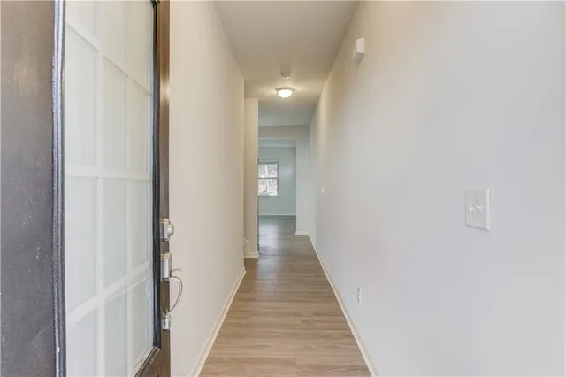 a view of a hallway with wooden floor and staircase