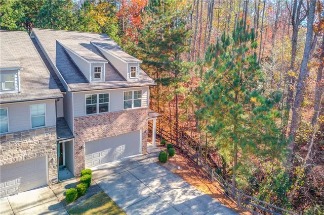 a aerial view of a house with a yard and large trees