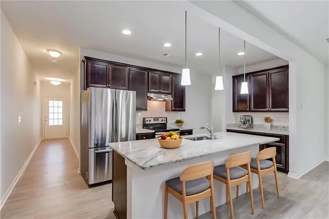 a kitchen with stainless steel appliances a sink stove and refrigerator