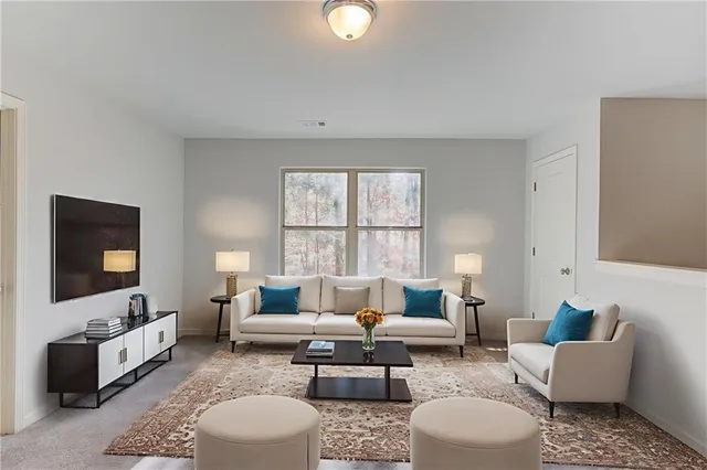 a living room with furniture a flat screen tv and a window
