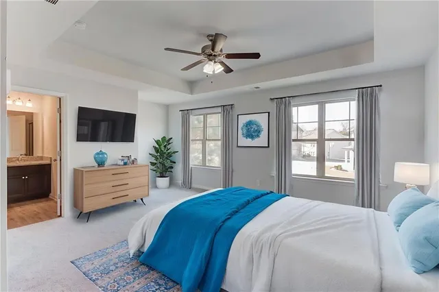 a spacious bedroom with a bed and a flat screen tv