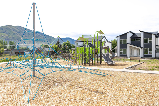 3115 South 200 West, Unit C201 Nibley, UT 84321 - Photo 23 of 23 Community playground featuring a rope climbing structure, slide, and wood chip ground cover