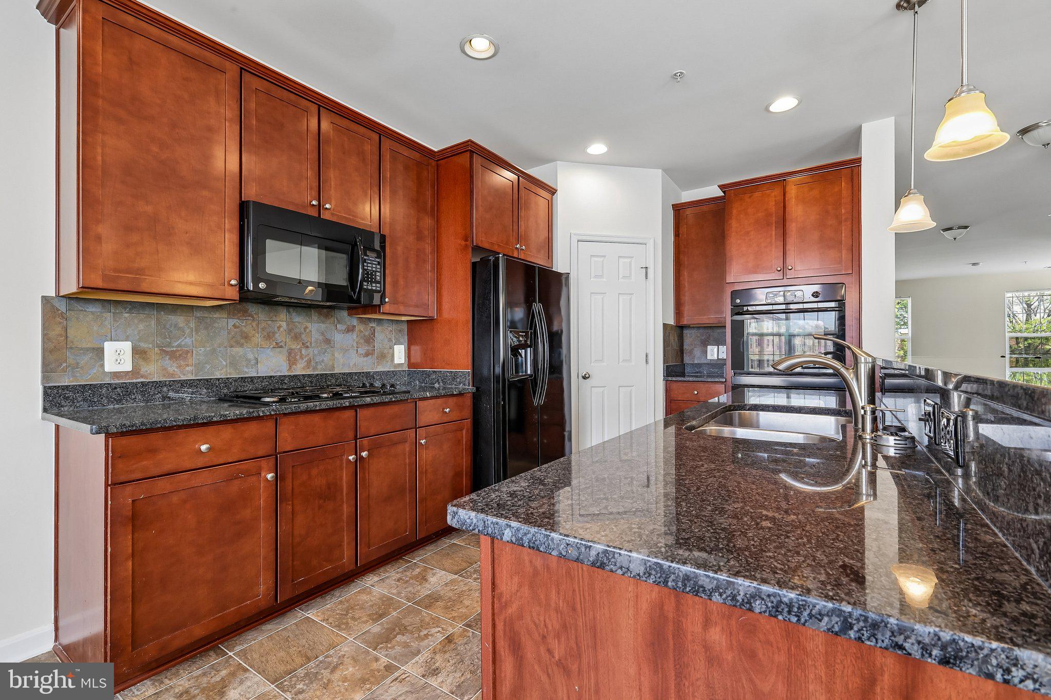 9581 Center Street Manassas, VA 20110 - Photo 11 of 25 a kitchen with stainless steel appliances granite countertop a sink microwave and stove