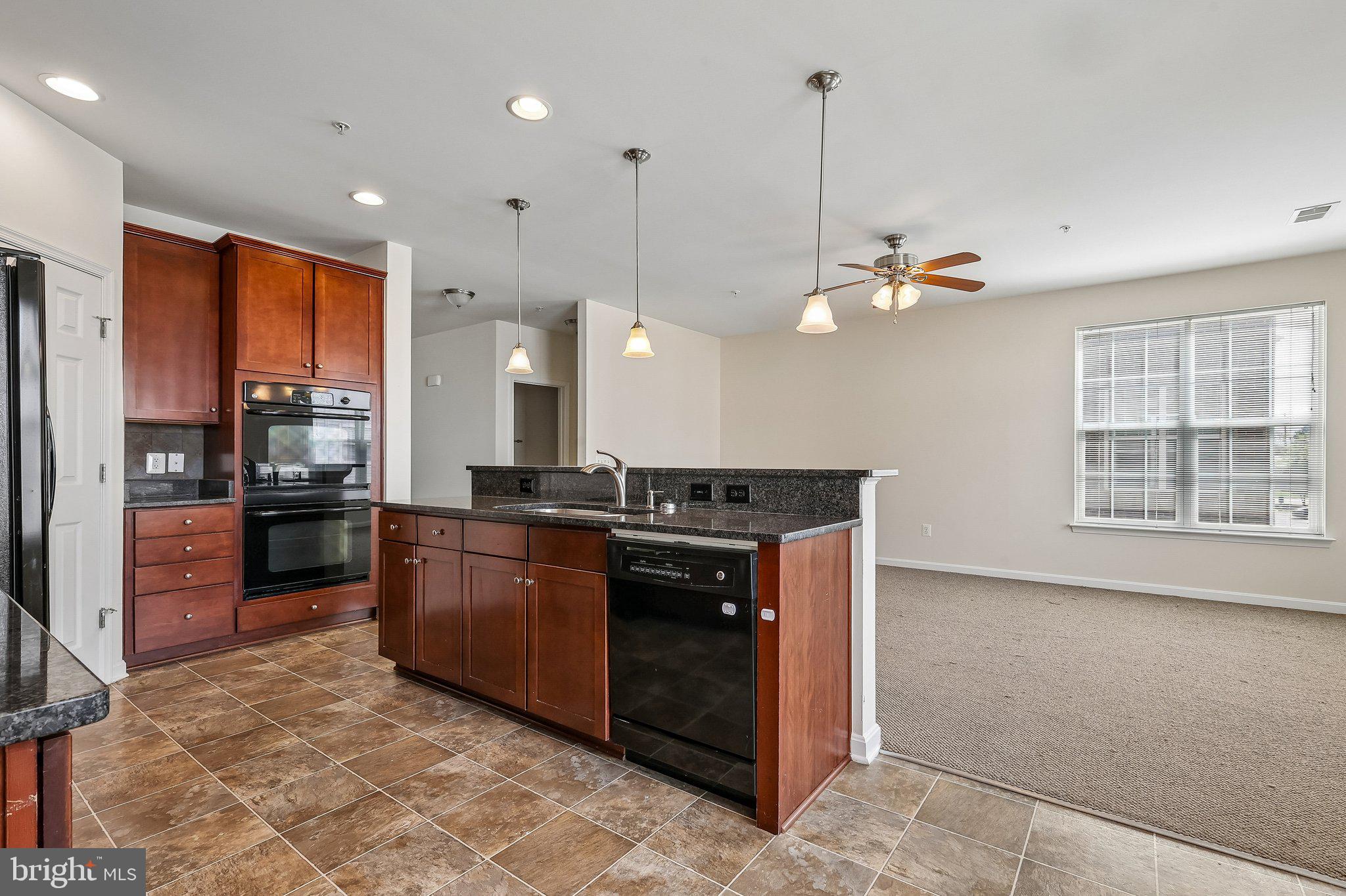 9581 Center Street Manassas, VA 20110 - Photo 12 of 25 a kitchen with stainless steel appliances granite countertop a sink a stove and a refrigerator