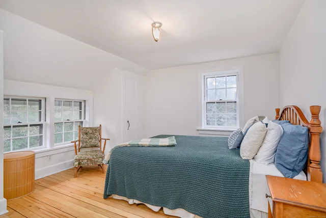 a bedroom with a bed and a wooden floor