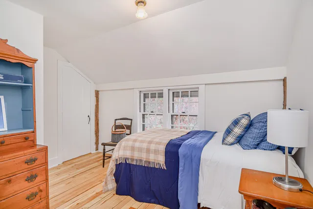a bedroom with a bed a dresser and a window
