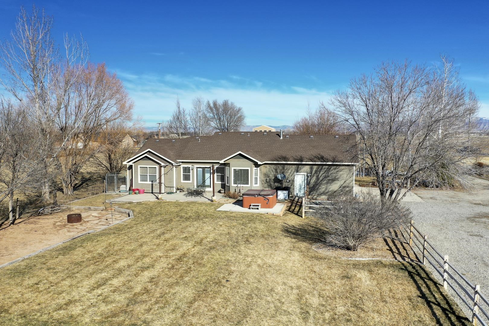 1885 J Road Fruita, CO 81521 - Photo 36 of 41 a view of a white house that has a big yard and a large tree