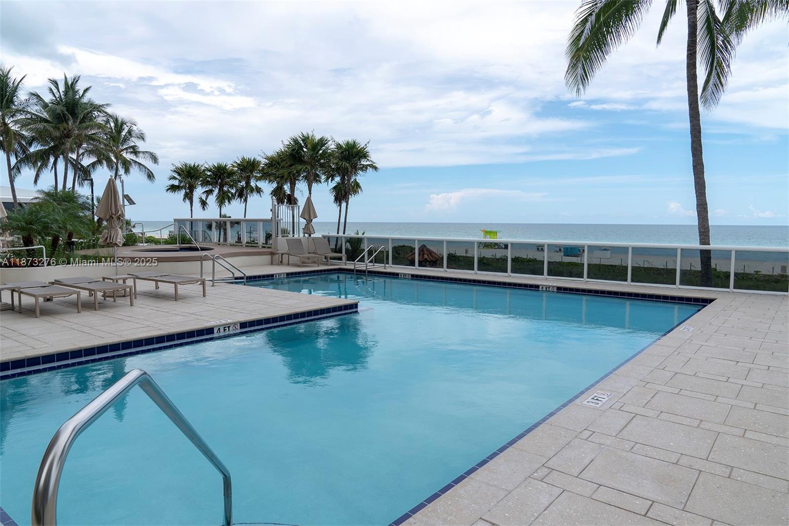 Millionaire's Row Miami Beach, FL 33140 - Photo 31 of 34 a view of a swimming pool with a lawn chairs under palm trees