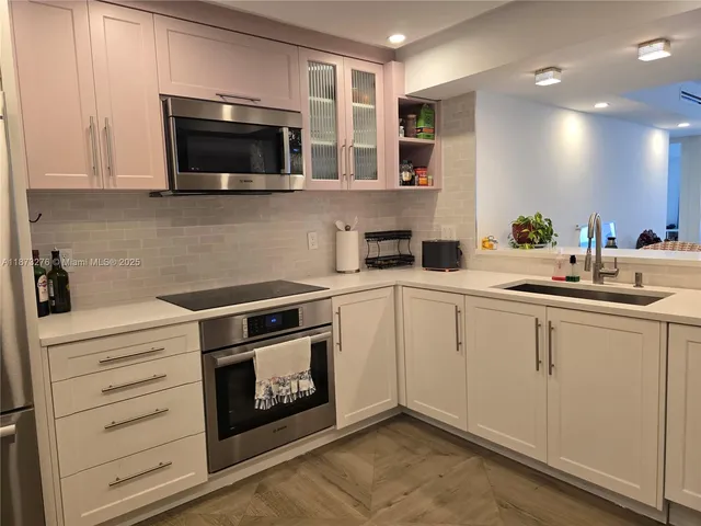 a kitchen with stainless steel appliances a stove microwave and sink