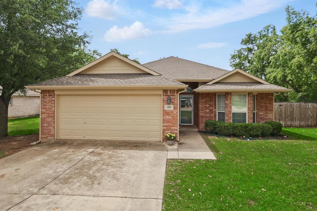 400 Stirling Road Rhome, TX 76078 - Photo 1 of 1 Ranch-style house featuring concrete driveway, an attached garage, brick siding, and roof with shingles