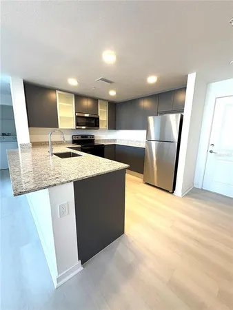 a kitchen with stainless steel appliances granite countertop a sink refrigerator and microwave