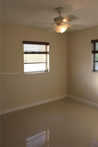 en empty room with windows and fan