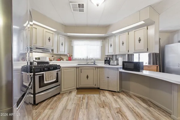 a kitchen with stainless steel appliances a refrigerator sink and stove