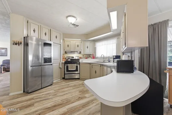 a kitchen with a sink and wooden floor