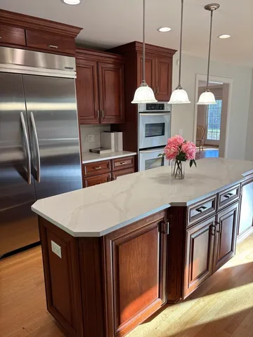 a kitchen with stainless steel appliances granite countertop a kitchen island a stove and a sink