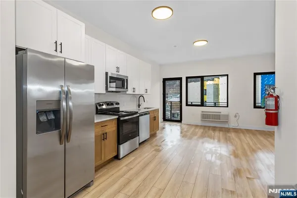 a kitchen with granite countertop a refrigerator stove and oven