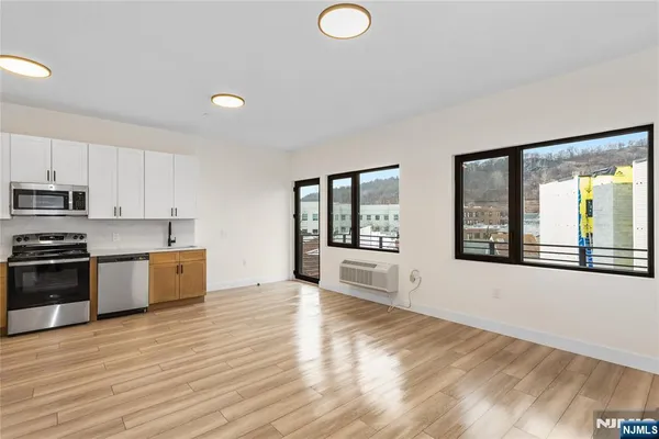a large kitchen with stainless steel appliances granite countertop a stove a sink and a large window