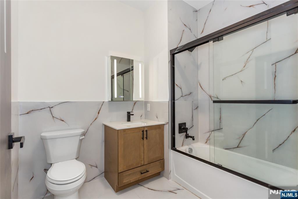 89 Mary Street, Unit 502 Paterson, NJ 07503 - Photo 7 of 13 a bathroom with a toilet sink and mirror