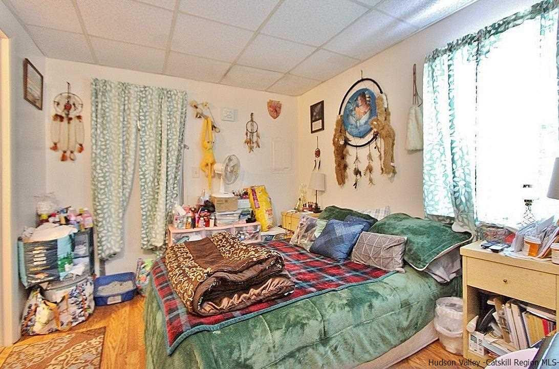 779 Neighborhood Road Lake Katrine, NY 12449 - Photo 13 of 26 a bedroom with a bed and a table in it with window