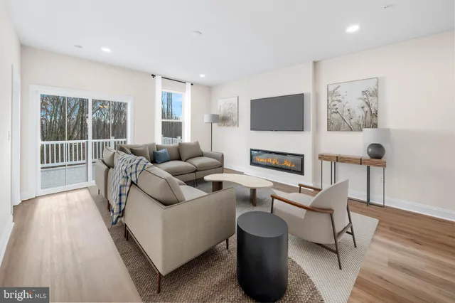 a living room with furniture a flat screen tv and a floor to ceiling window