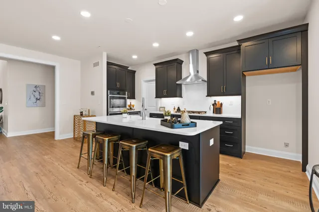 a kitchen with kitchen island stainless steel appliances a sink and a refrigerator