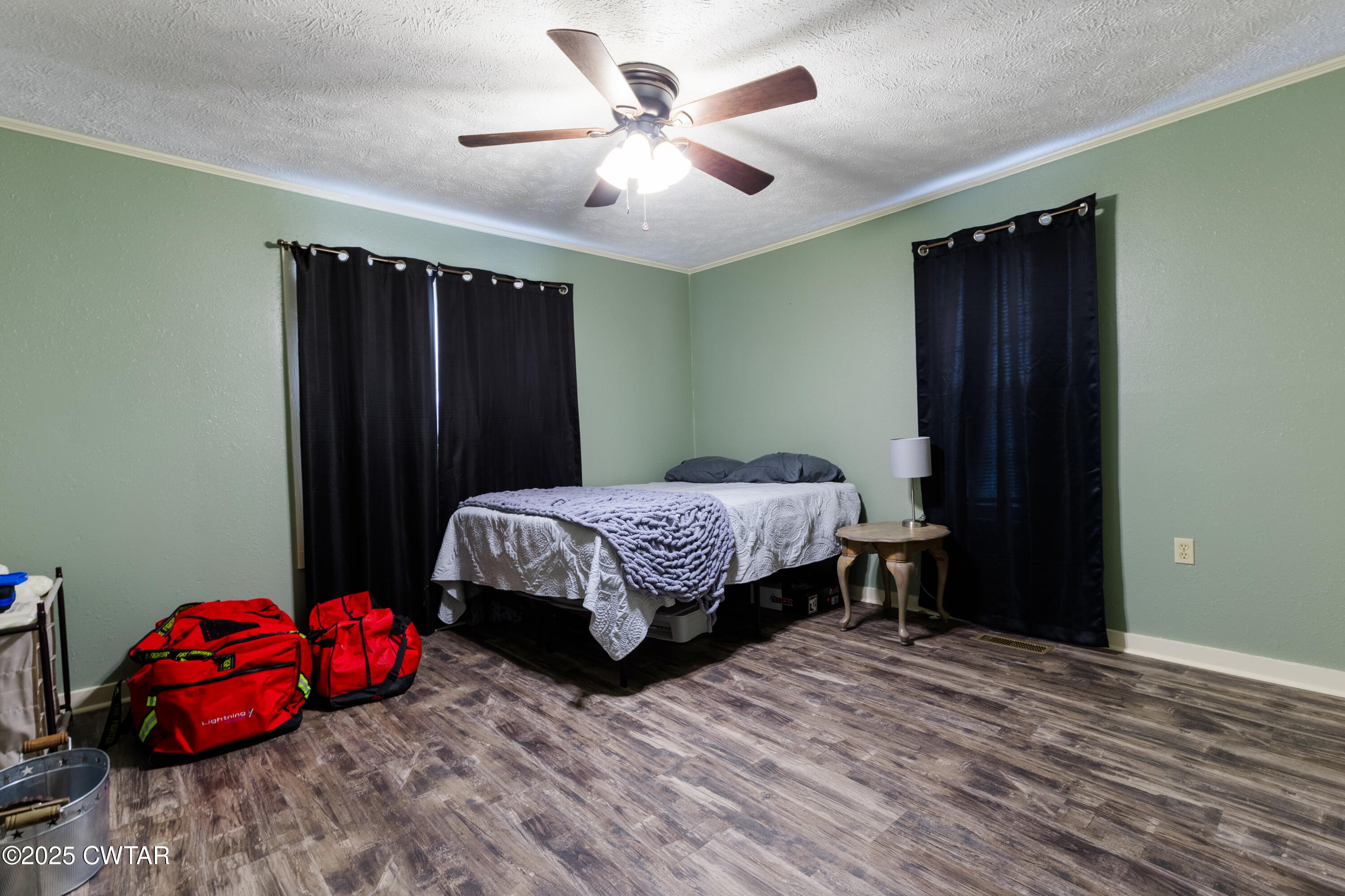 47 Peace Chapel Road Scotts Hill, TN 38374 - Photo 18 of 28 a bedroom with a bed and a chandelier