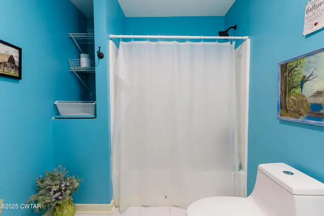 a bathroom with a toilet and a shower