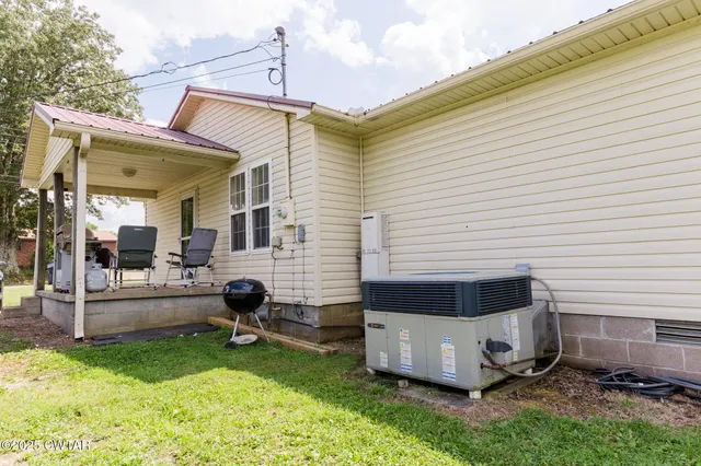 a view of a chair and table in backyard of the house