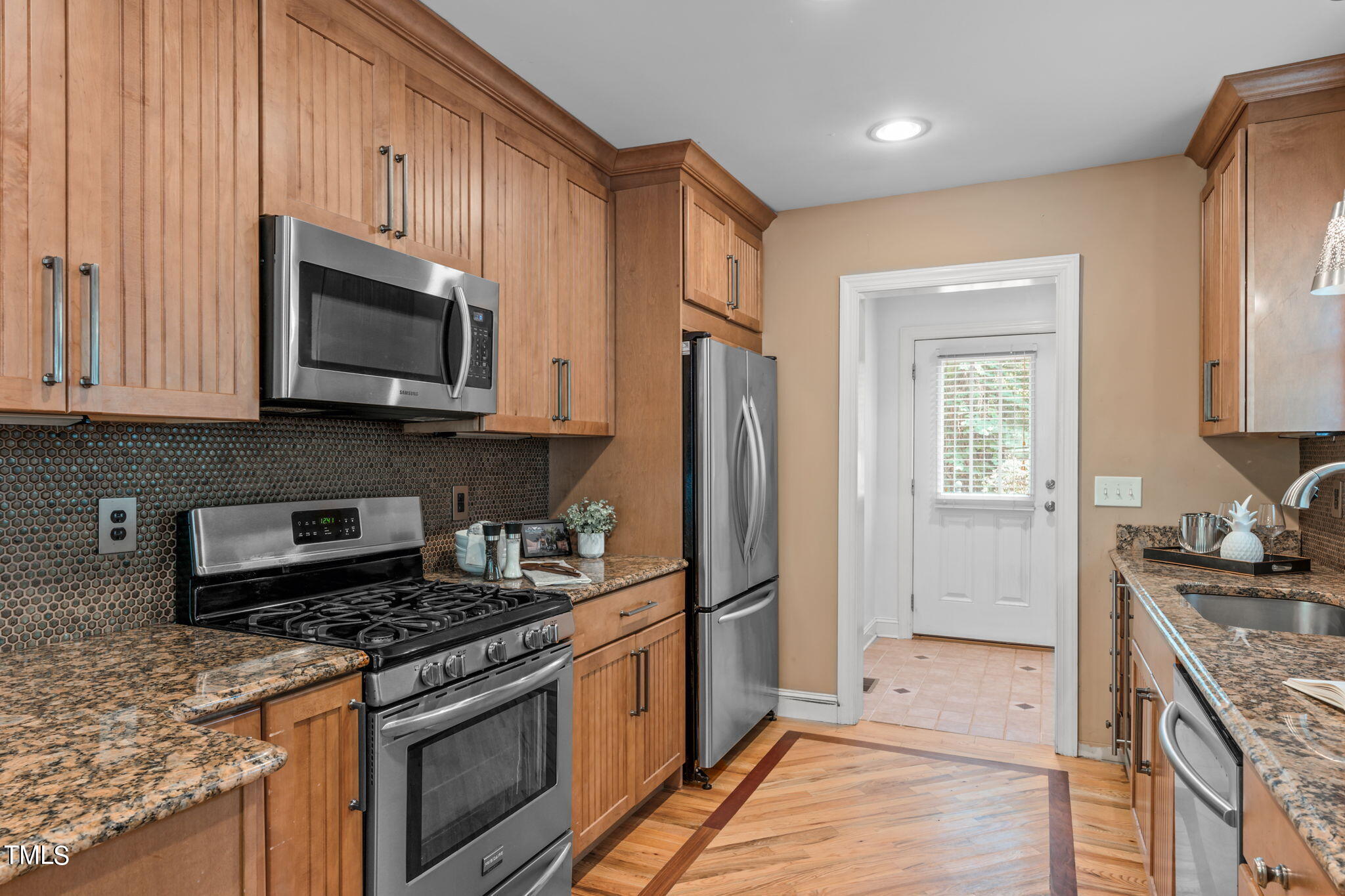 2006 McCarthy Street Raleigh, NC 27608 - Photo 15 of 40 a kitchen with stainless steel appliances granite countertop a stove microwave refrigerator and sink