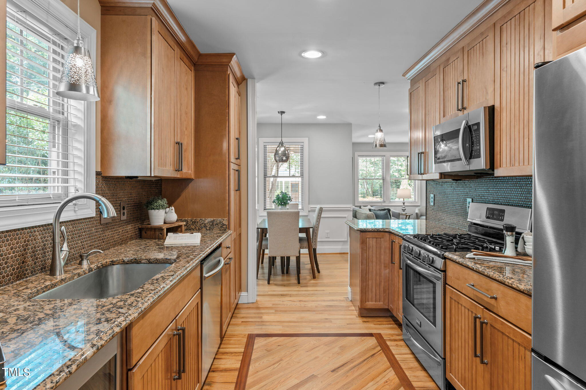 2006 McCarthy Street Raleigh, NC 27608 - Photo 16 of 40 a kitchen with kitchen island granite countertop a sink appliances cabinets and a counter top space