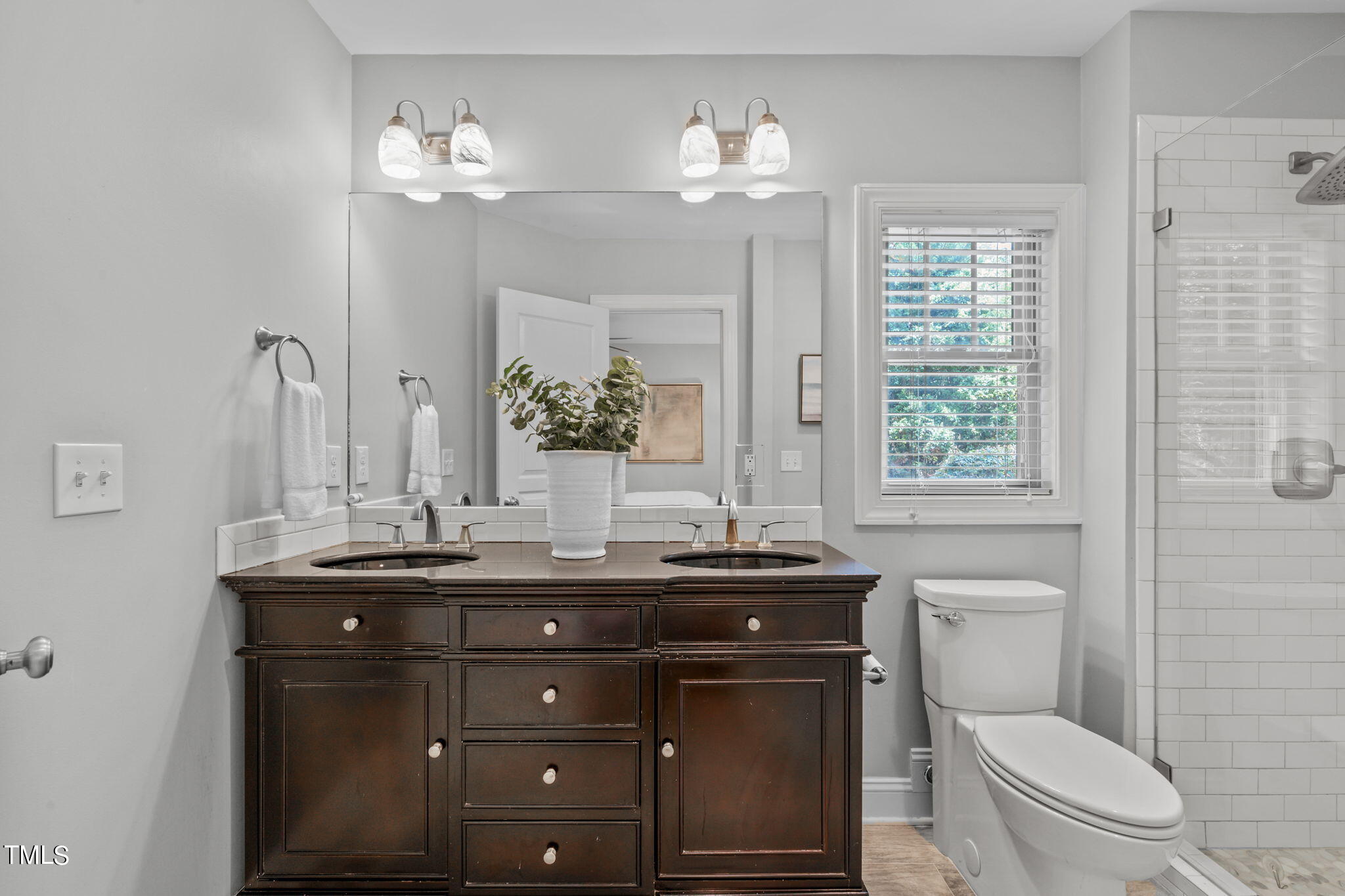2006 McCarthy Street Raleigh, NC 27608 - Photo 23 of 40 a bathroom with a granite countertop toilet sink and mirror