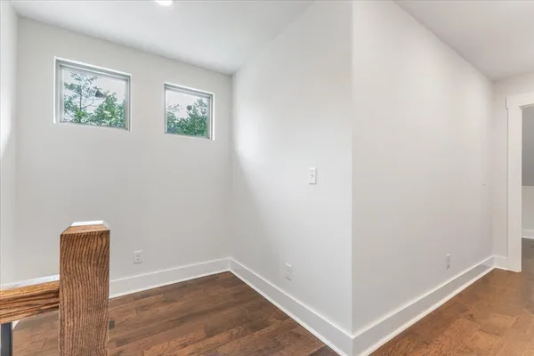 an empty room with wooden floor and a window
