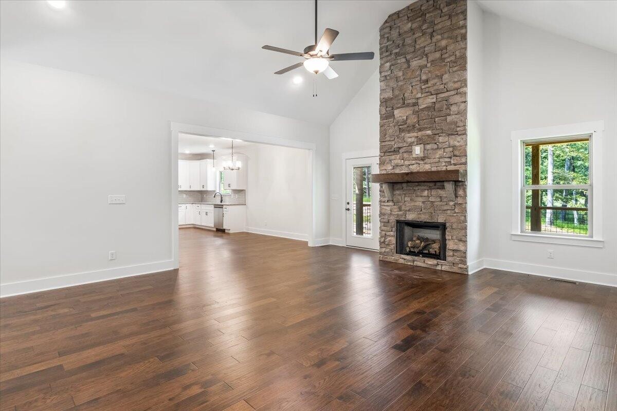 7391 Gamble Road Georgetown, TN 37336 - Photo 5 of 27 an empty room with wooden floor fireplace and windows
