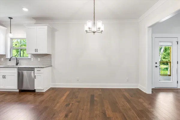 a view of a kitchen with a sink a chandelier and wooden floor