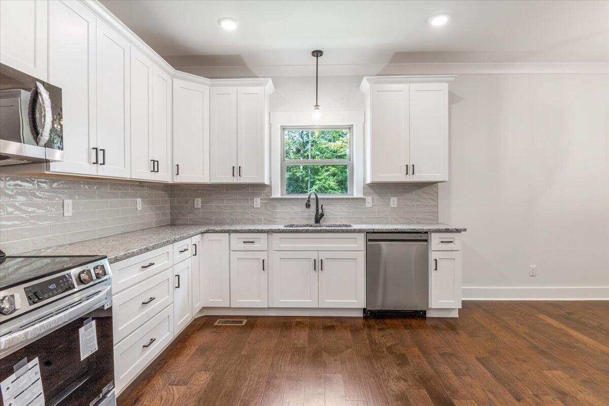 7391 Gamble Road Georgetown, TN 37336 - Photo 9 of 27 a kitchen with stainless steel appliances granite countertop a sink and cabinets with wooden floors