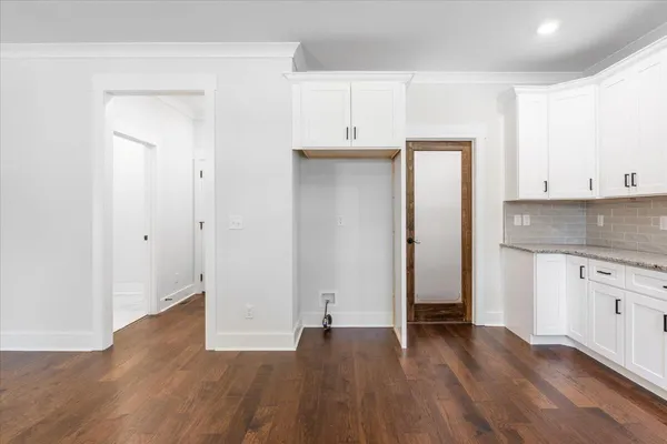 an empty room with wooden floor and cabinets