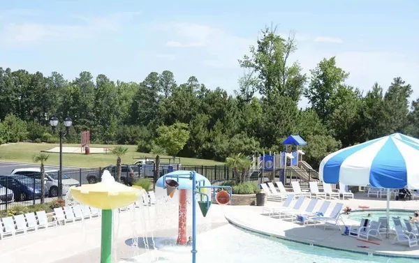 a view of a swimming pool with lawn chairs and a big yard