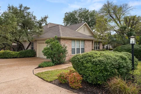a view of a house with garden and a tree